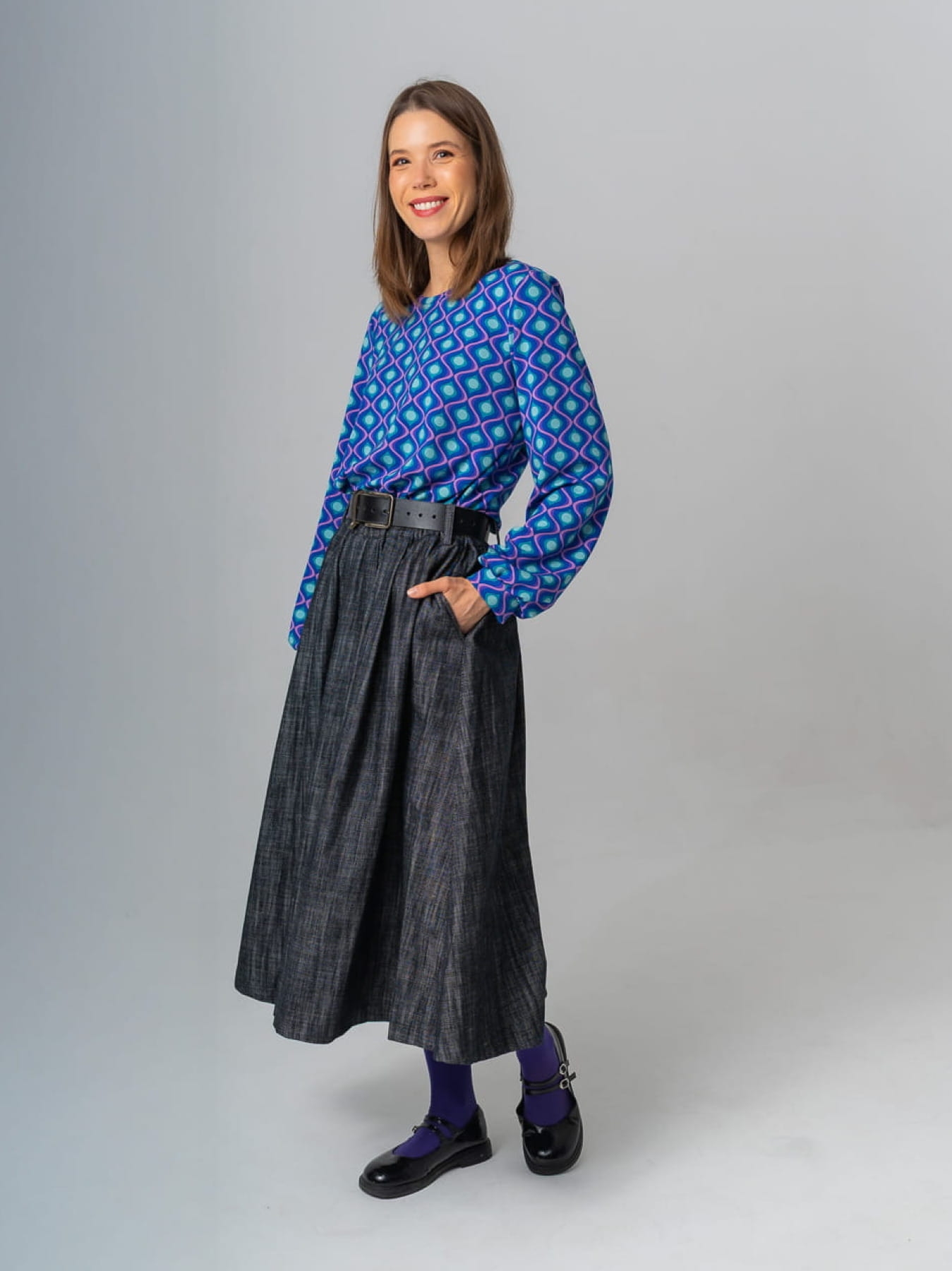 Modelka w granatowej spódnicy AURELIA z jeansu o żakardowej fakturze, długość midi, rozkloszowany krój.