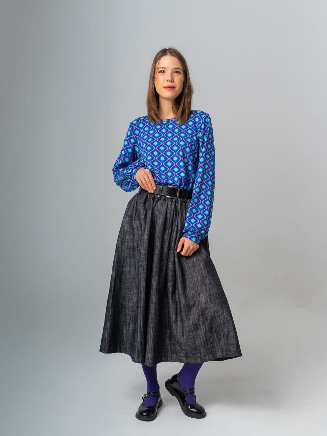 Modelka w granatowej spódnicy AURELIA z jeansu o żakardowej fakturze, długość midi, rozkloszowany krój.