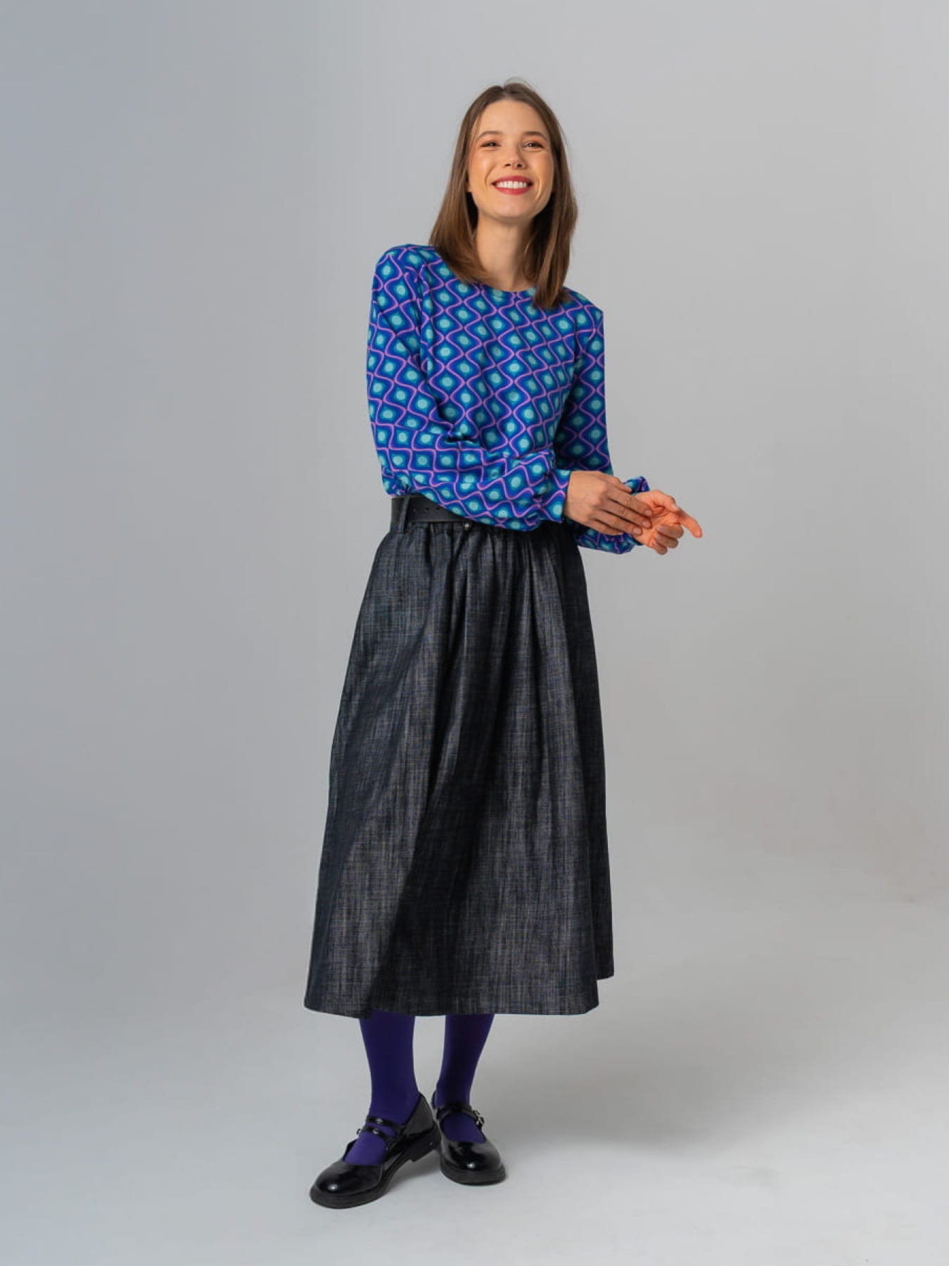 Modelka w granatowej spódnicy AURELIA z jeansu o żakardowej fakturze, długość midi, rozkloszowany krój.