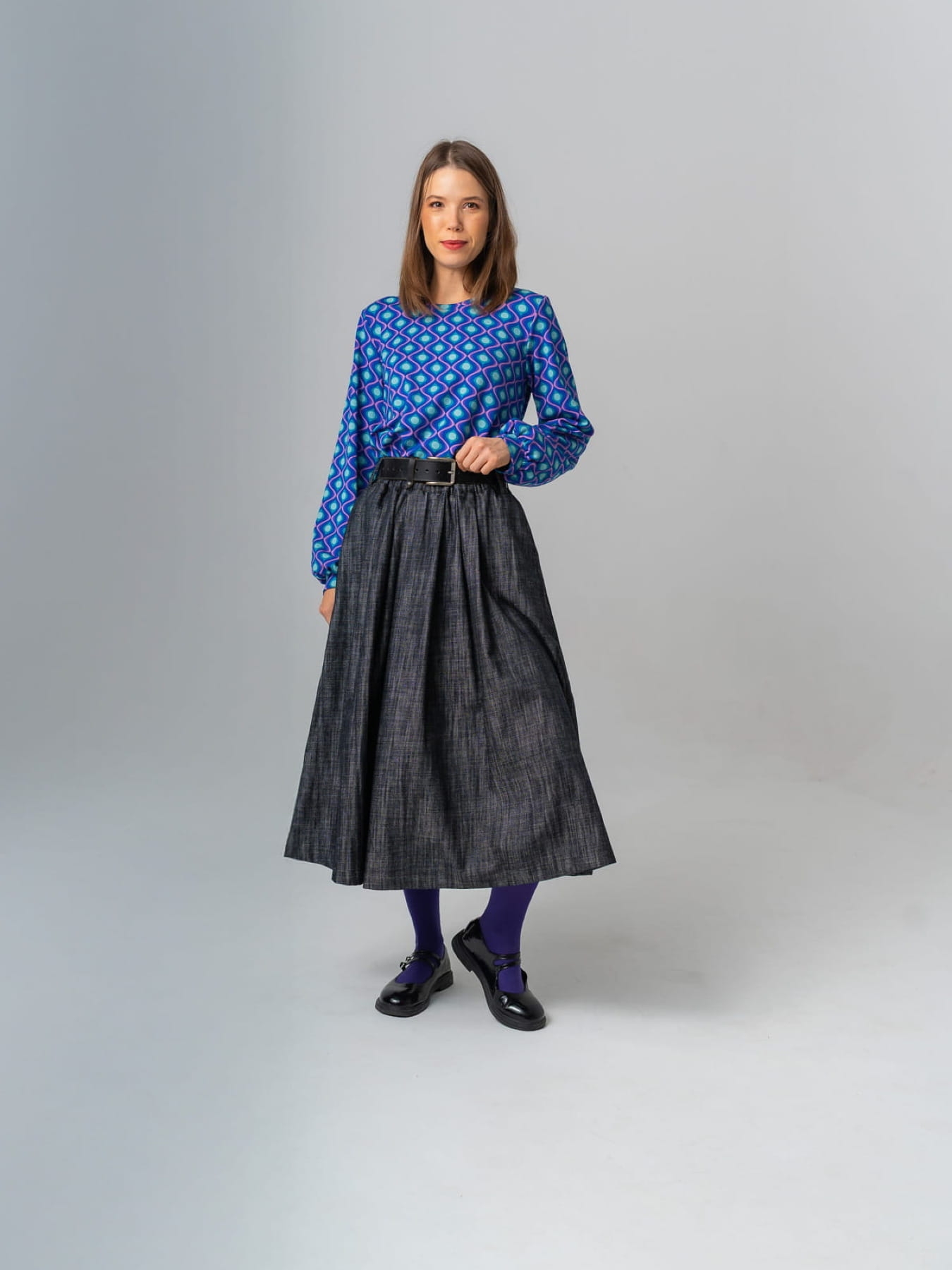 Modelka w granatowej spódnicy AURELIA z jeansu o żakardowej fakturze, długość midi, rozkloszowany krój.