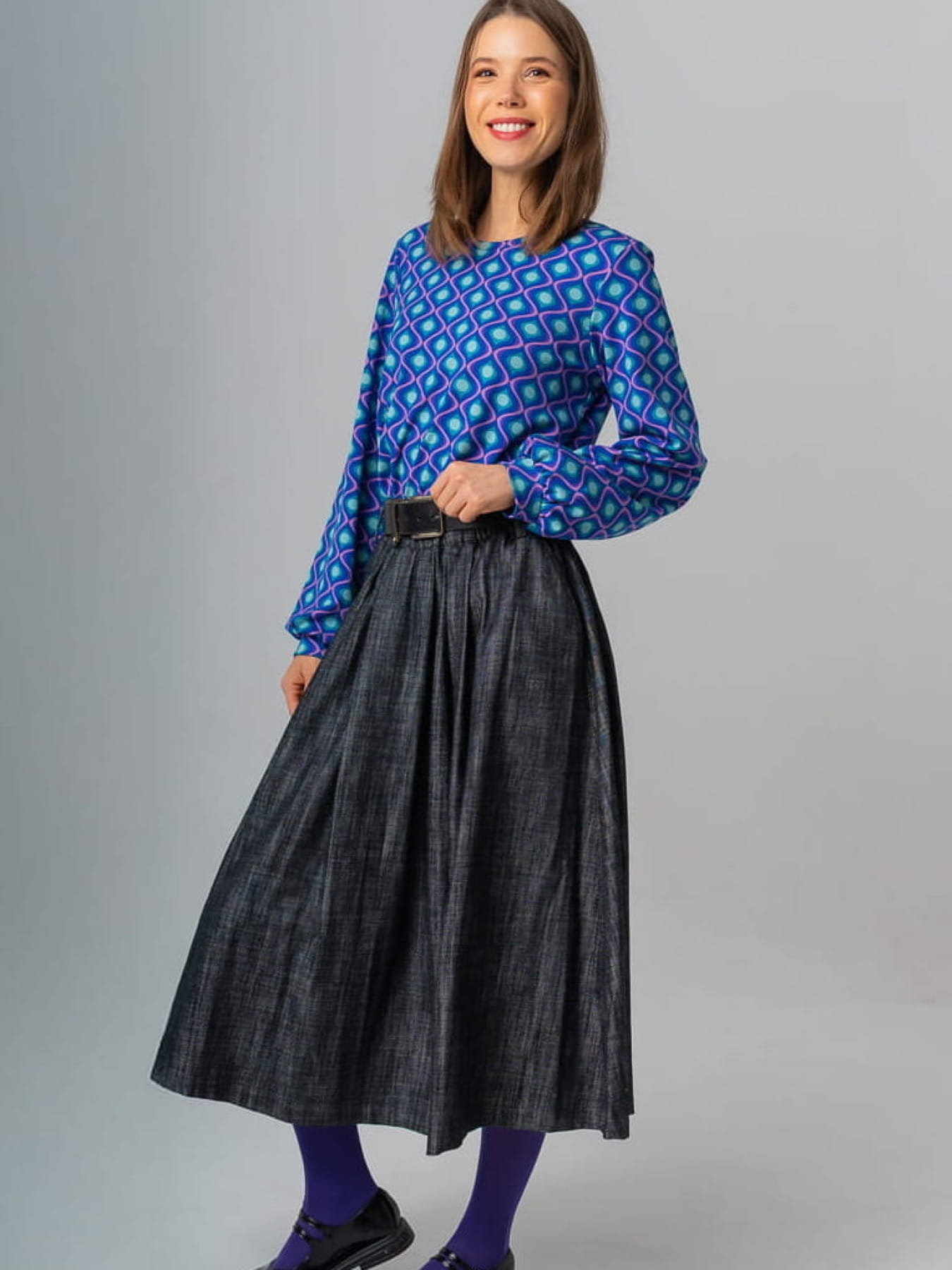 Modelka w granatowej spódnicy AURELIA z jeansu o żakardowej fakturze, długość midi, rozkloszowany krój.