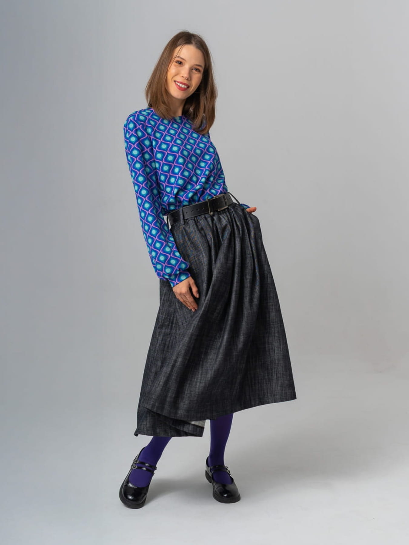 Modelka w granatowej spódnicy AURELIA z jeansu o żakardowej fakturze, długość midi, rozkloszowany krój.