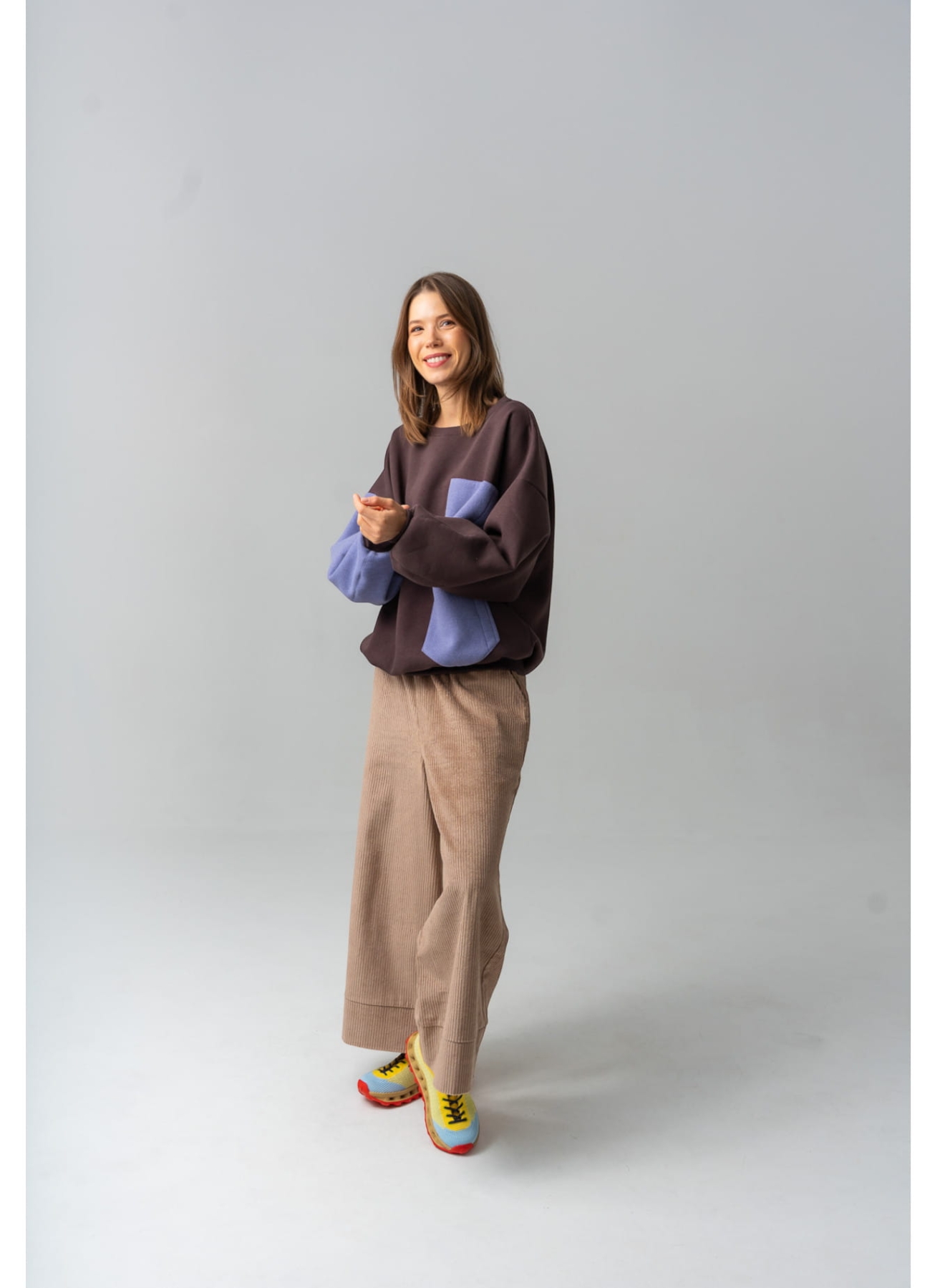 Modelka w brązowych kulotach COFFEE z bawełnianego sztruksu, z szerokimi nogawkami i gumką w pasie.