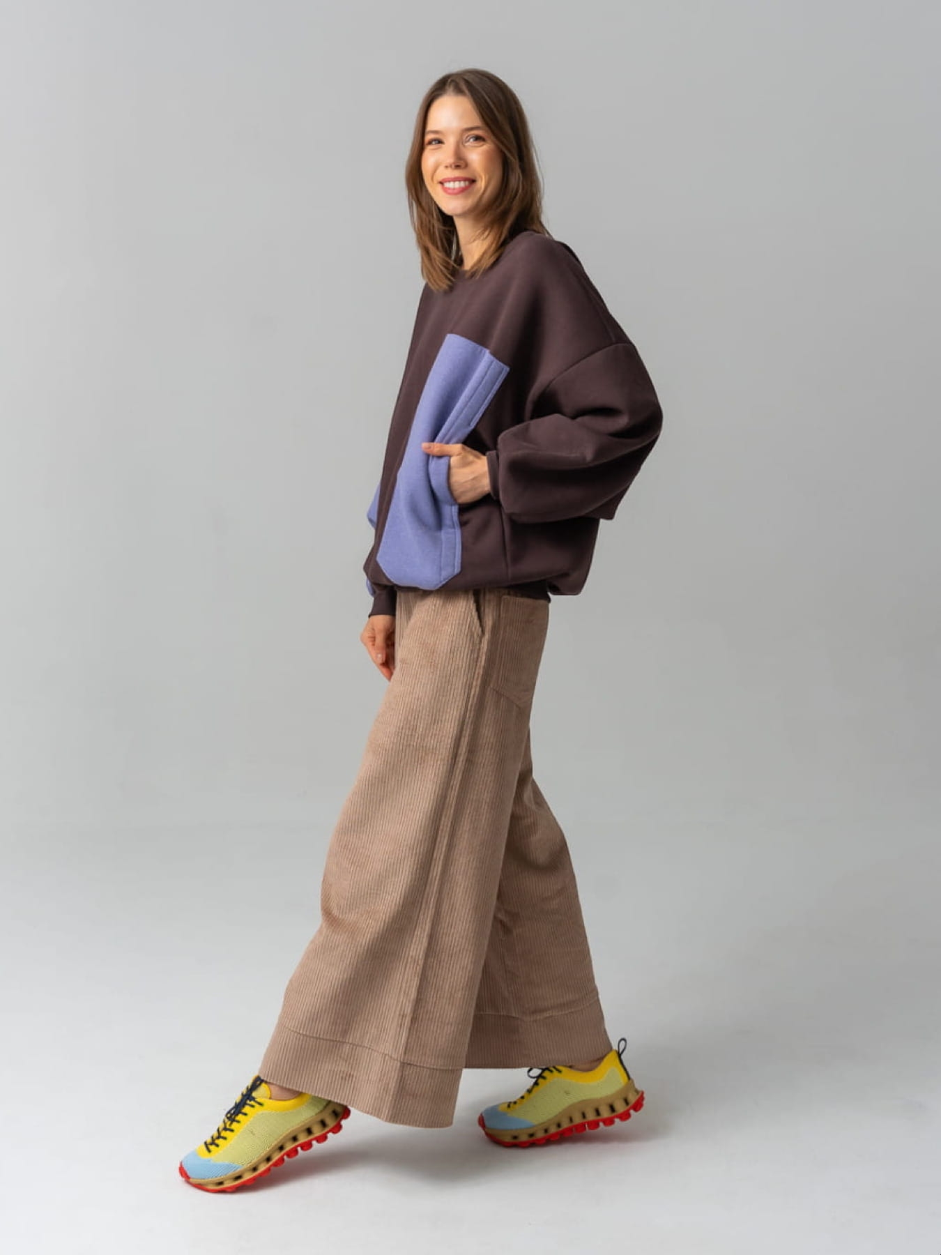 Modelka w brązowych kulotach COFFEE z bawełnianego sztruksu, z szerokimi nogawkami i gumką w pasie.