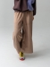 Modelka w brązowych kulotach COFFEE z bawełnianego sztruksu, z szerokimi nogawkami i gumką w pasie.