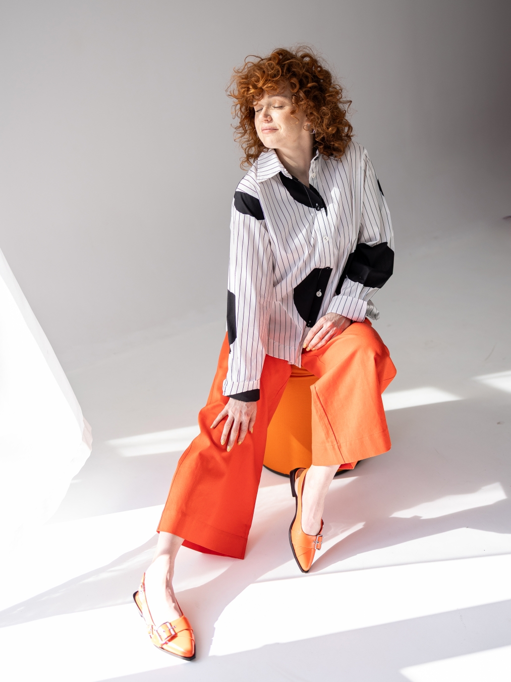 Koszula z lekkiej tkaniny w biało-czarnym kolorze, o luźnym kroju, z kołnierzykiem, mankietami oraz kontrastowym wzorem w paski i grochy.