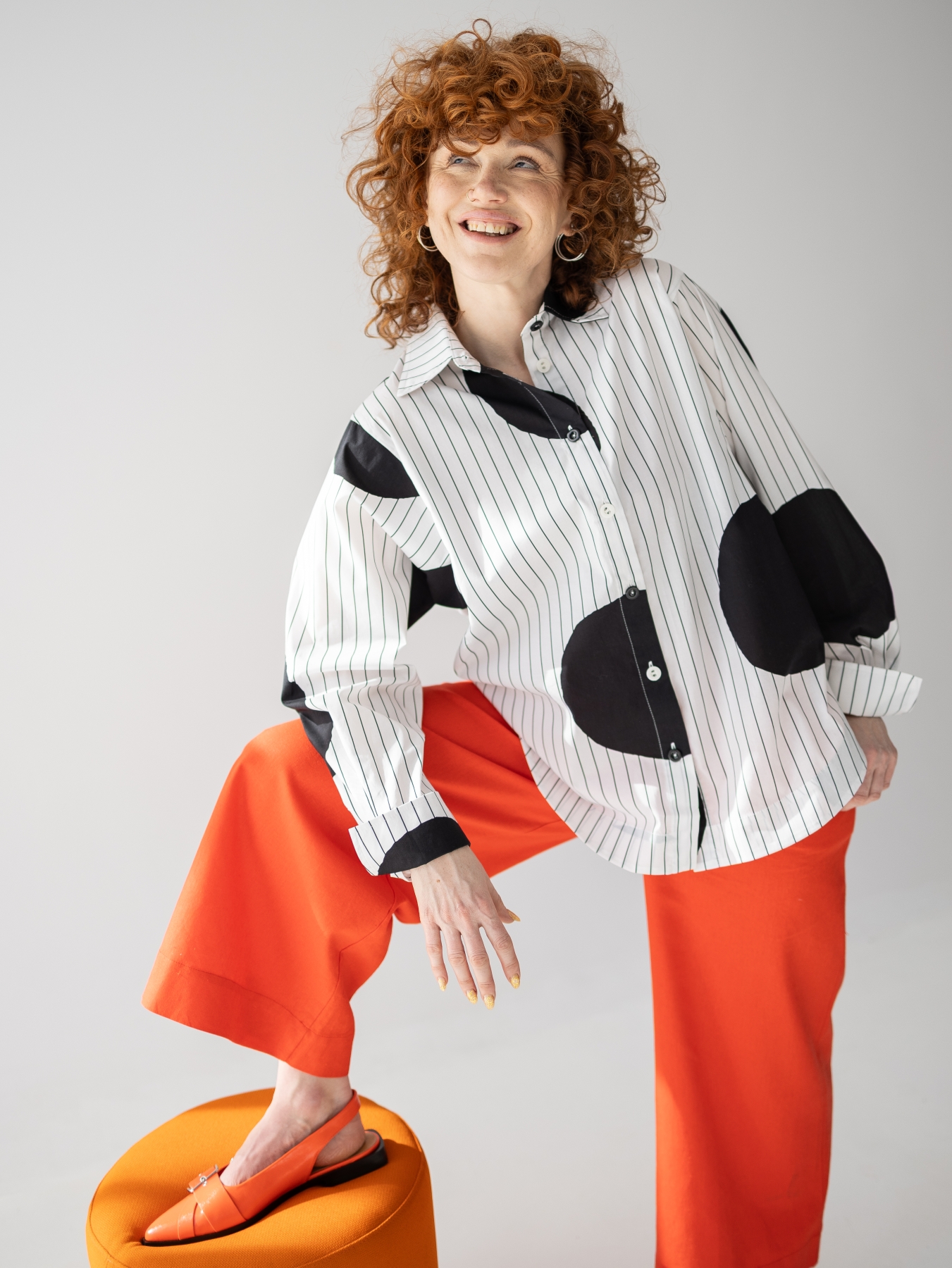 Koszula z lekkiej tkaniny w biało-czarnym kolorze, o luźnym kroju, z kołnierzykiem, mankietami oraz kontrastowym wzorem w paski i grochy.