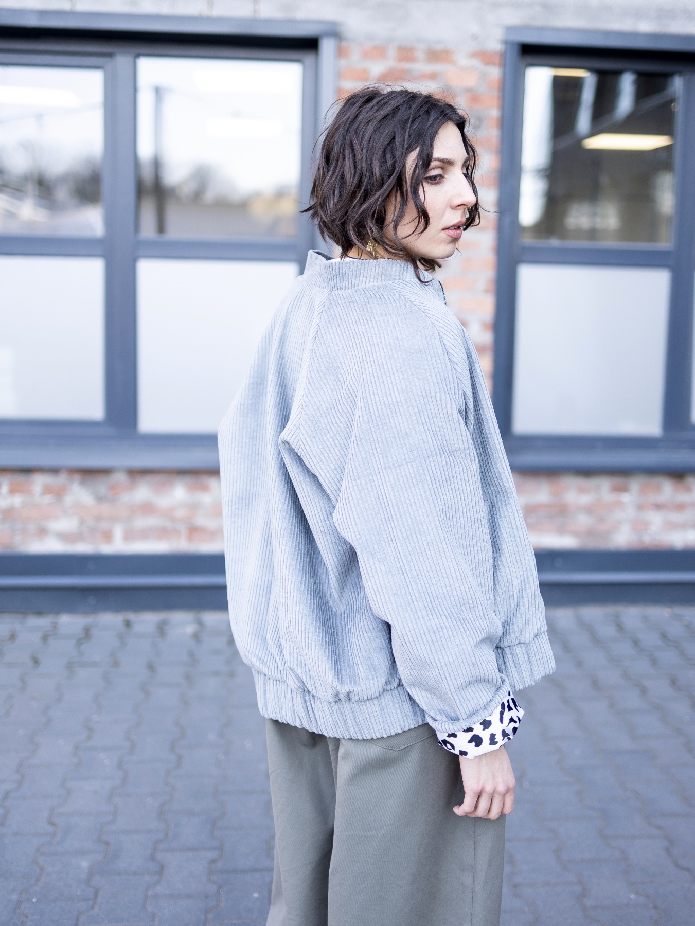 Jasnoszara kurtka bomber Livia z bawełnianego sztruksu, zapinana na suwak, z kontrastową wzorzystą podszewką.