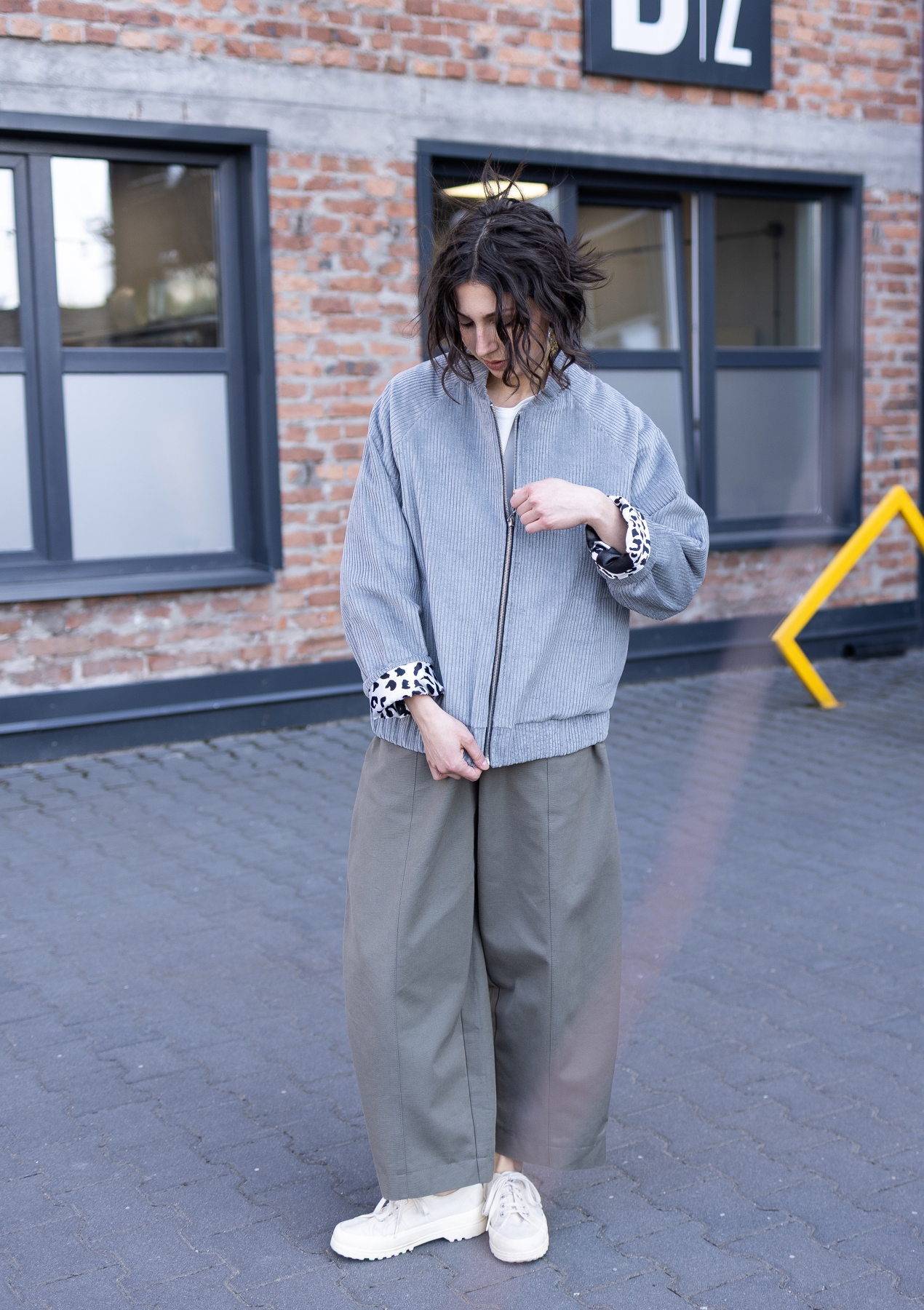 Jasnoszara kurtka bomber Livia z bawełnianego sztruksu, zapinana na suwak, z kontrastową wzorzystą podszewką.