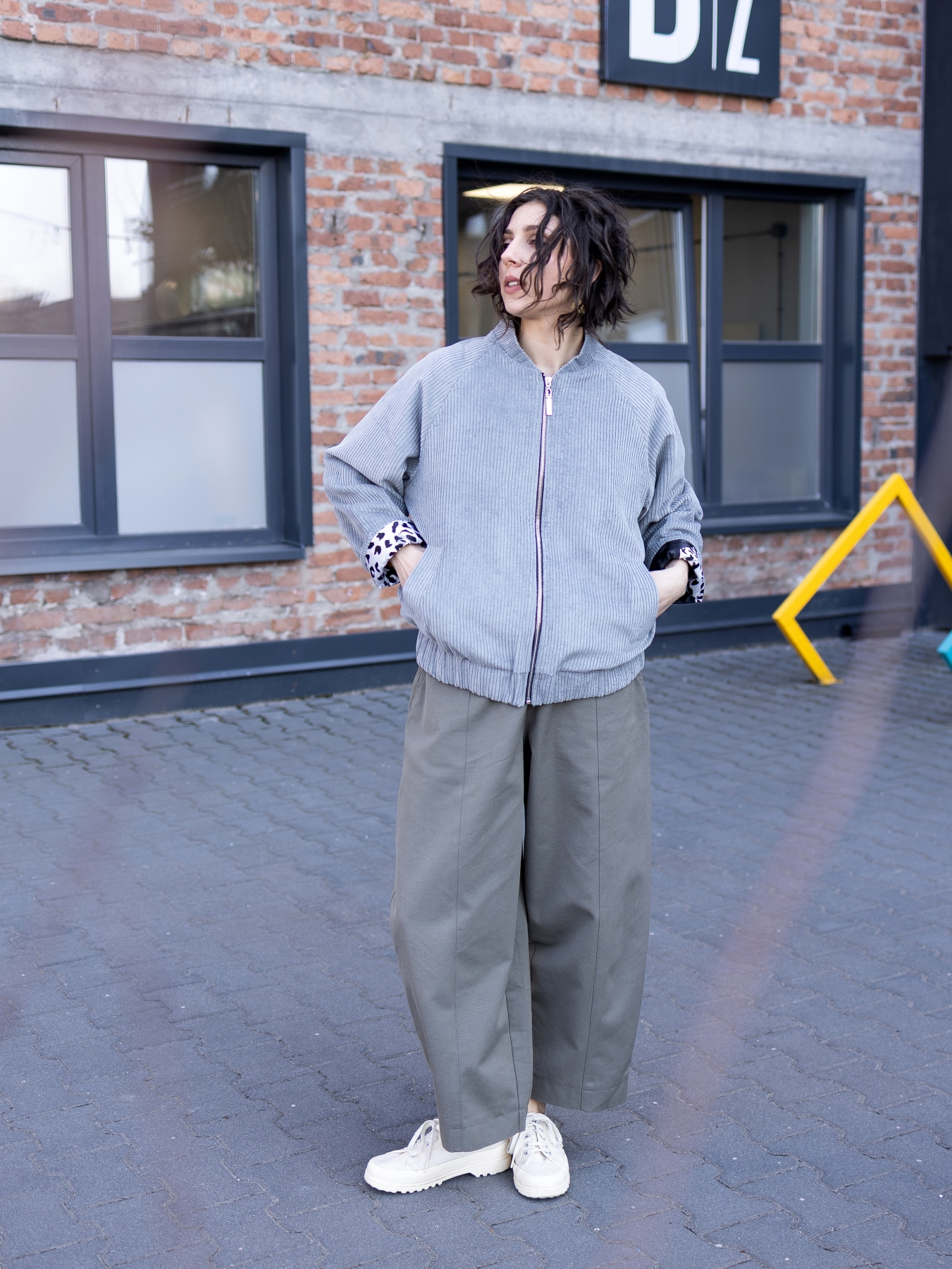 Jasnoszara kurtka bomber Livia z bawełnianego sztruksu, zapinana na suwak, z kontrastową wzorzystą podszewką.