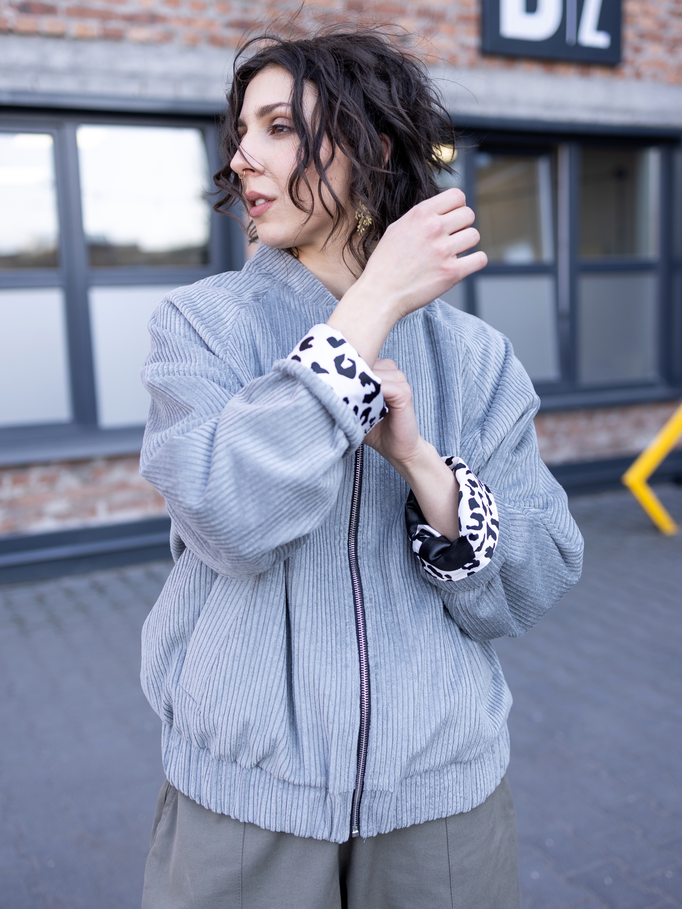 Jasnoszara kurtka bomber Livia z bawełnianego sztruksu, zapinana na suwak, z kontrastową wzorzystą podszewką.