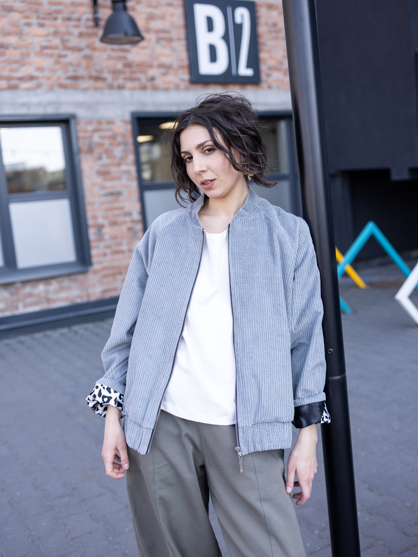 Jasnoszara kurtka bomber Livia z bawełnianego sztruksu, zapinana na suwak, z kontrastową wzorzystą podszewką.