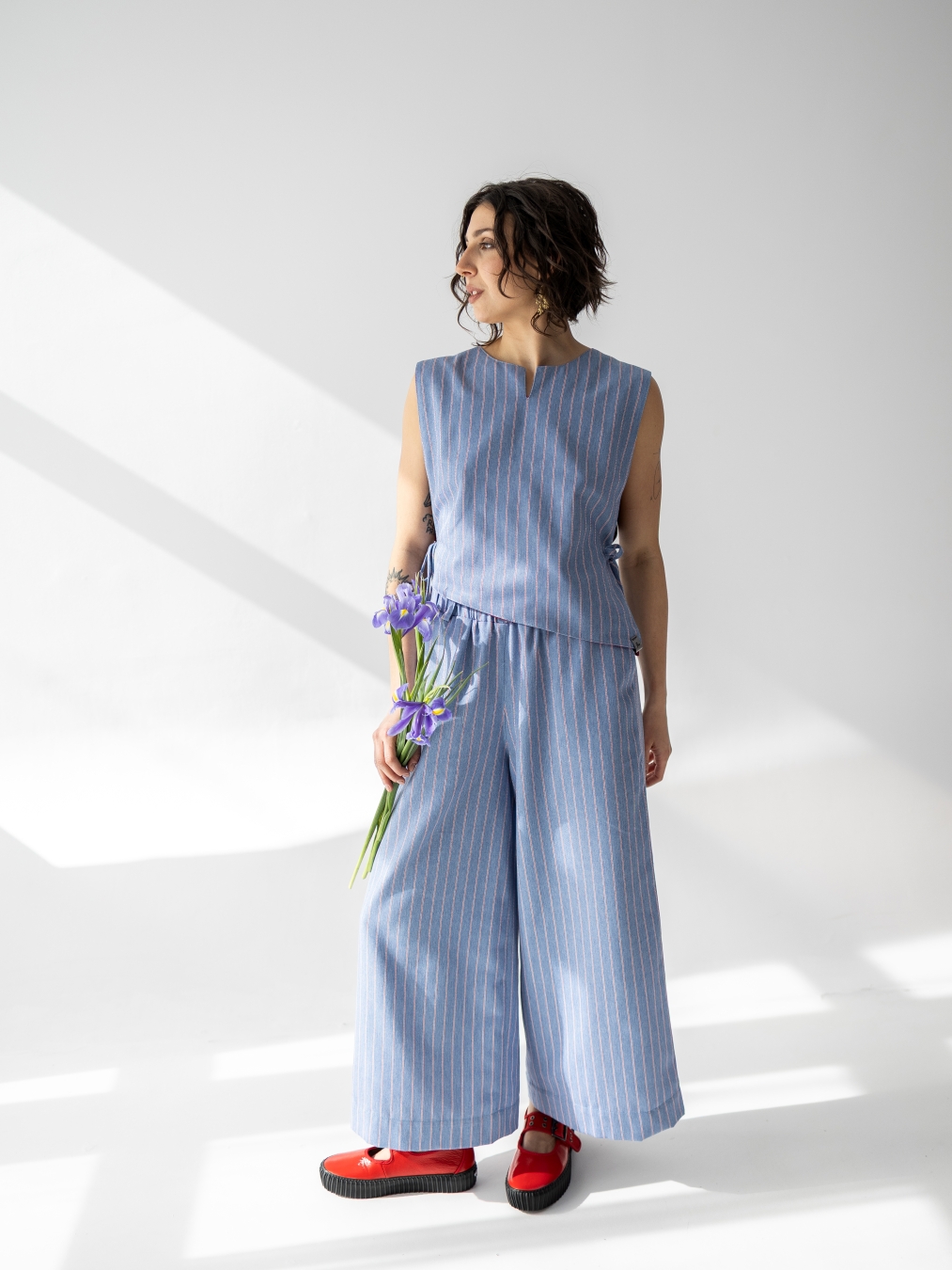 Jasnoniebieskie spodnie Lucia 7/8 z szerokimi nogawkami i pionowym prążkiem.