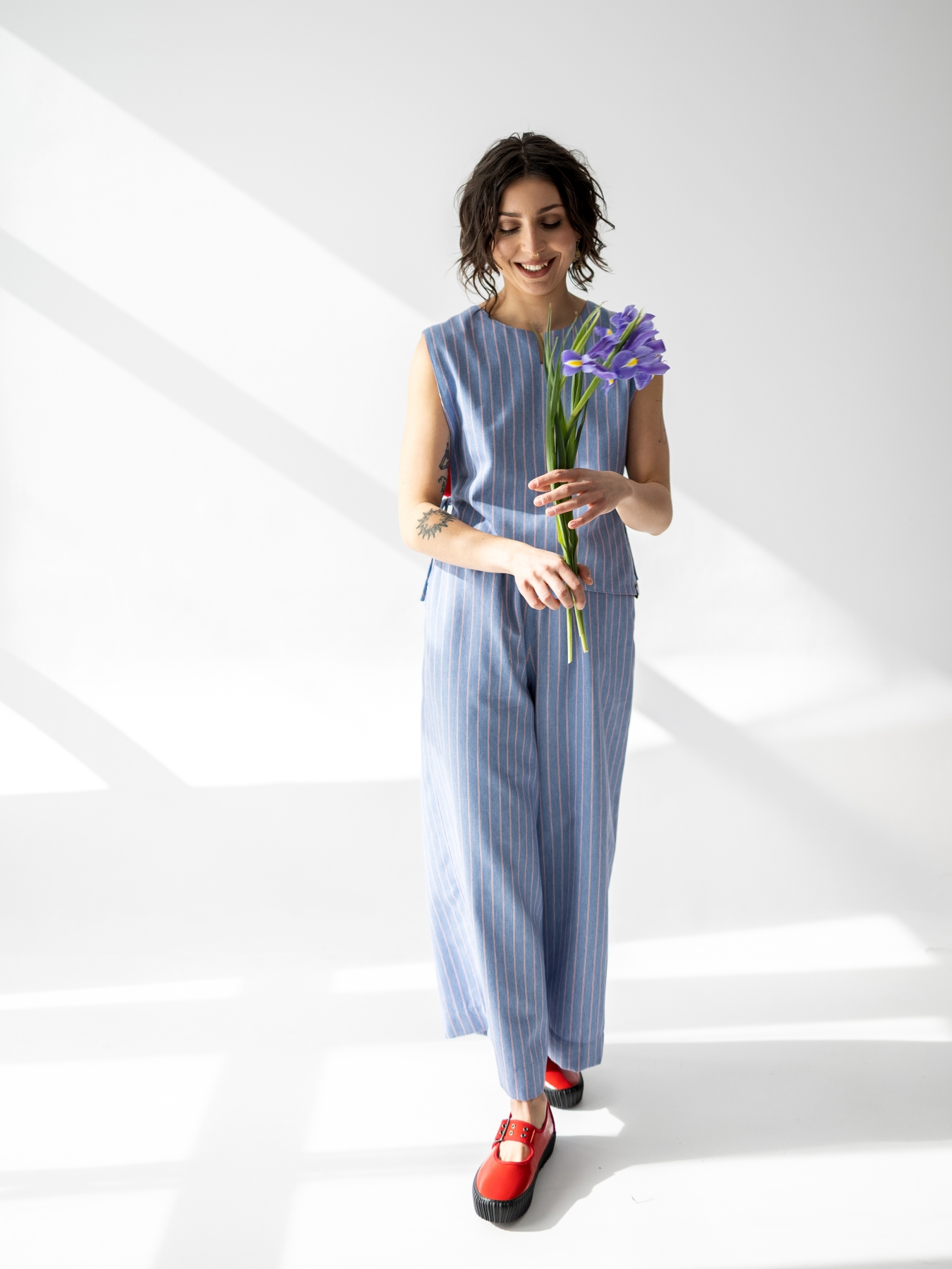 Jasnoniebieskie spodnie Lucia 7/8 z szerokimi nogawkami i pionowym prążkiem.