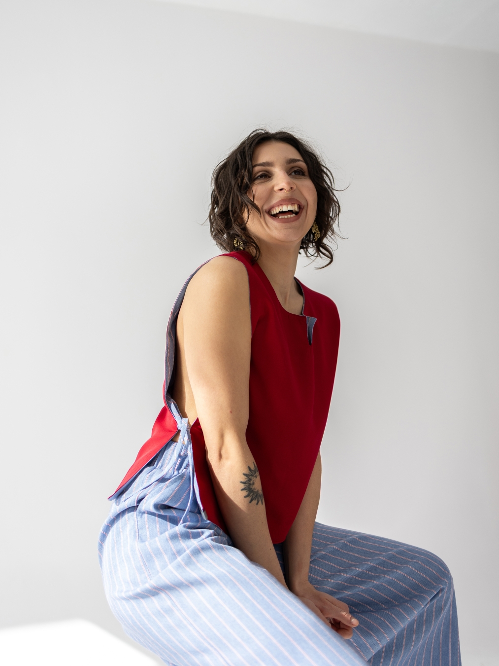 Dwustronna kamizelka Lucia bez rękawów, czerwona z jednej strony i w jasnoniebieski prążek z drugiej.