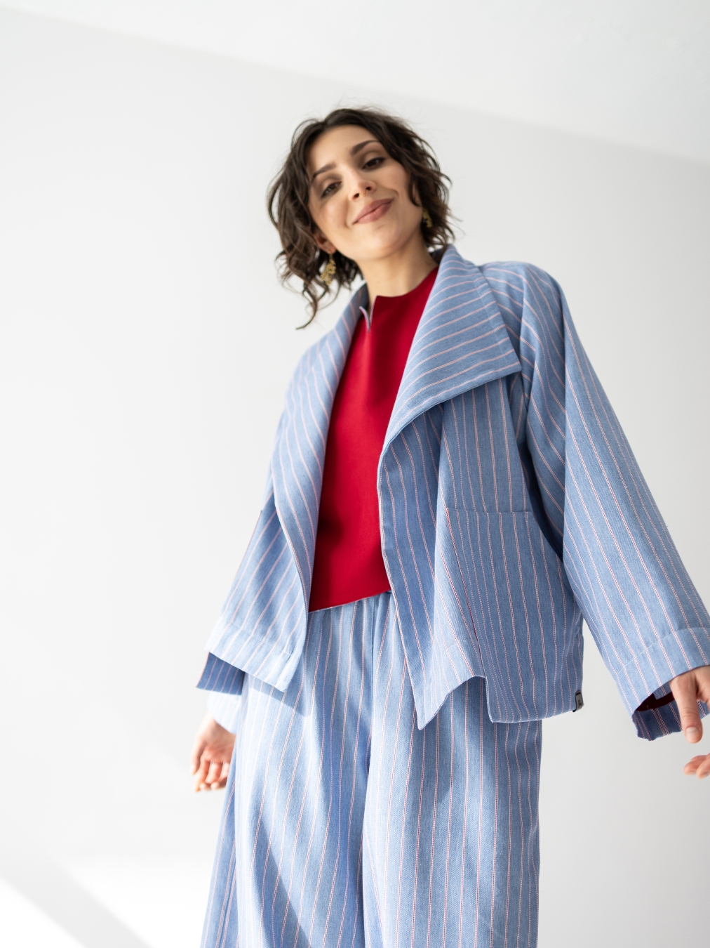 Jasnoniebieskie kimono Lucia w pionowy prążek, o luźnym fasonie i szerokim kołnierzu.