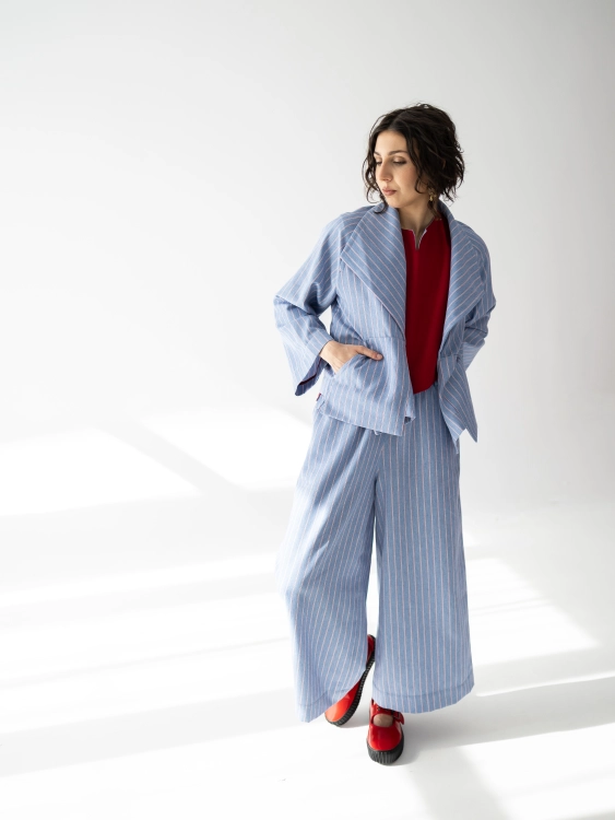 Jasnoniebieskie kimono Lucia w pionowy prążek, o luźnym fasonie i szerokim kołnierzu.