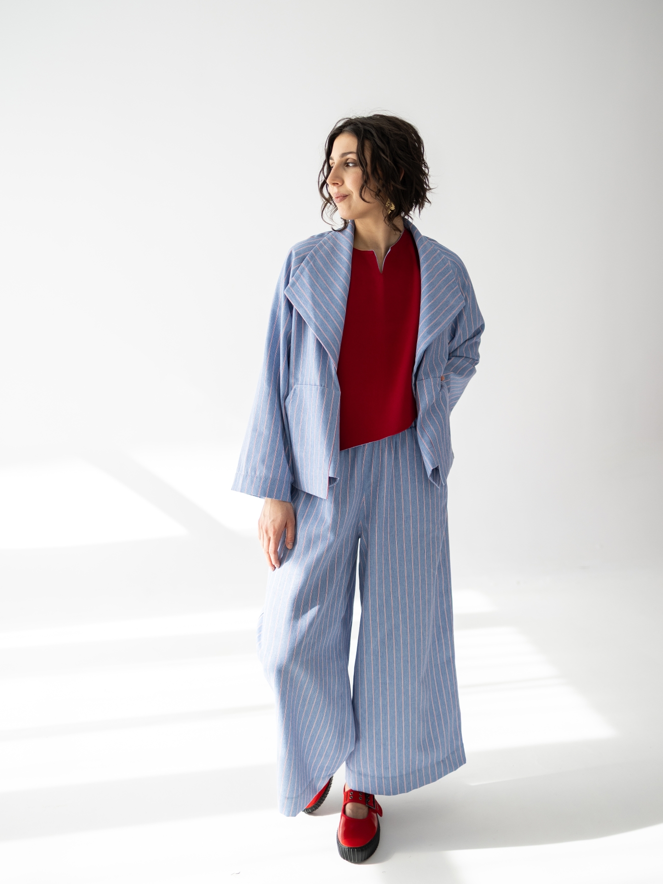 Jasnoniebieskie kimono Lucia w pionowy prążek, o luźnym fasonie i szerokim kołnierzu.