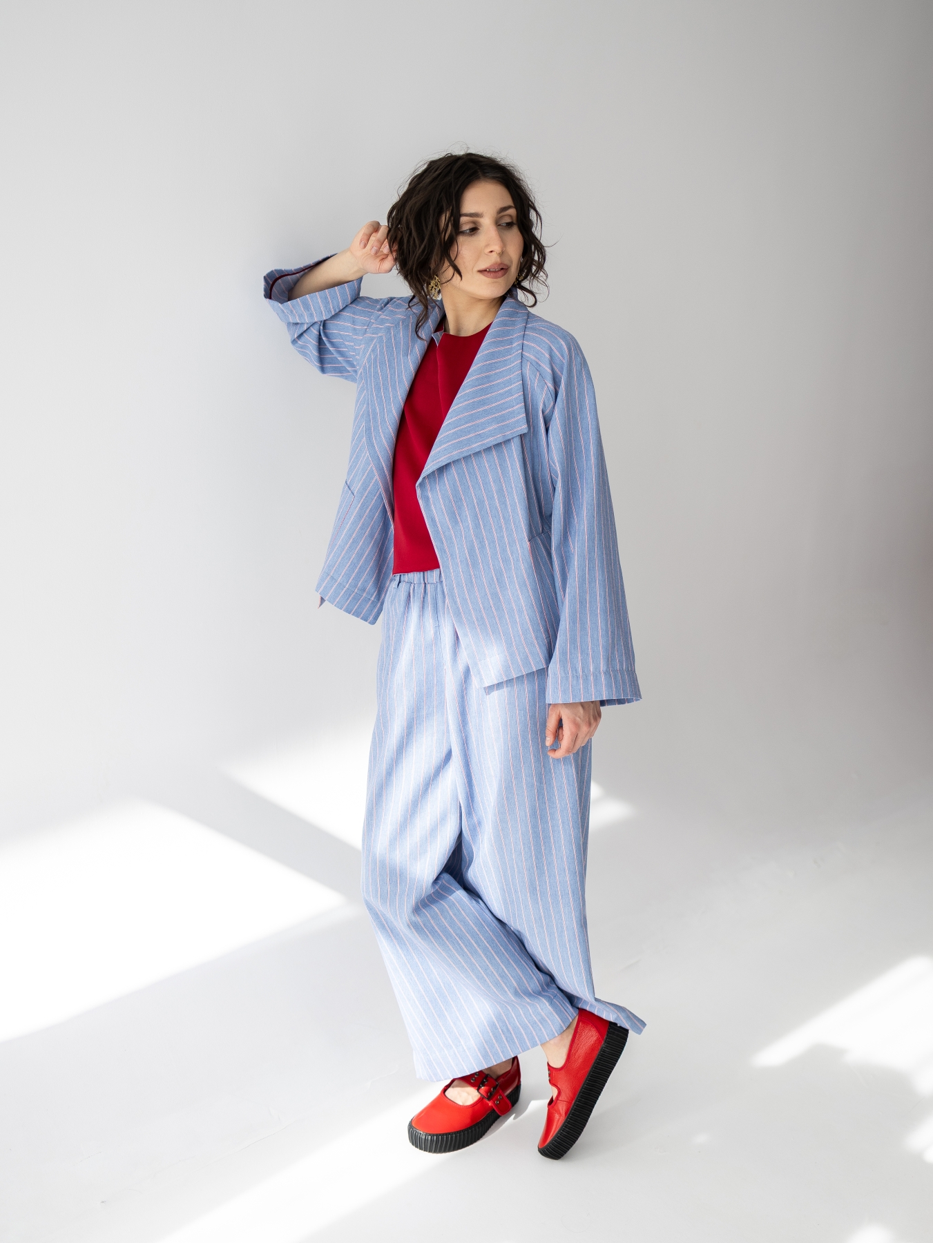 Jasnoniebieskie kimono Lucia w pionowy prążek, o luźnym fasonie i szerokim kołnierzu.