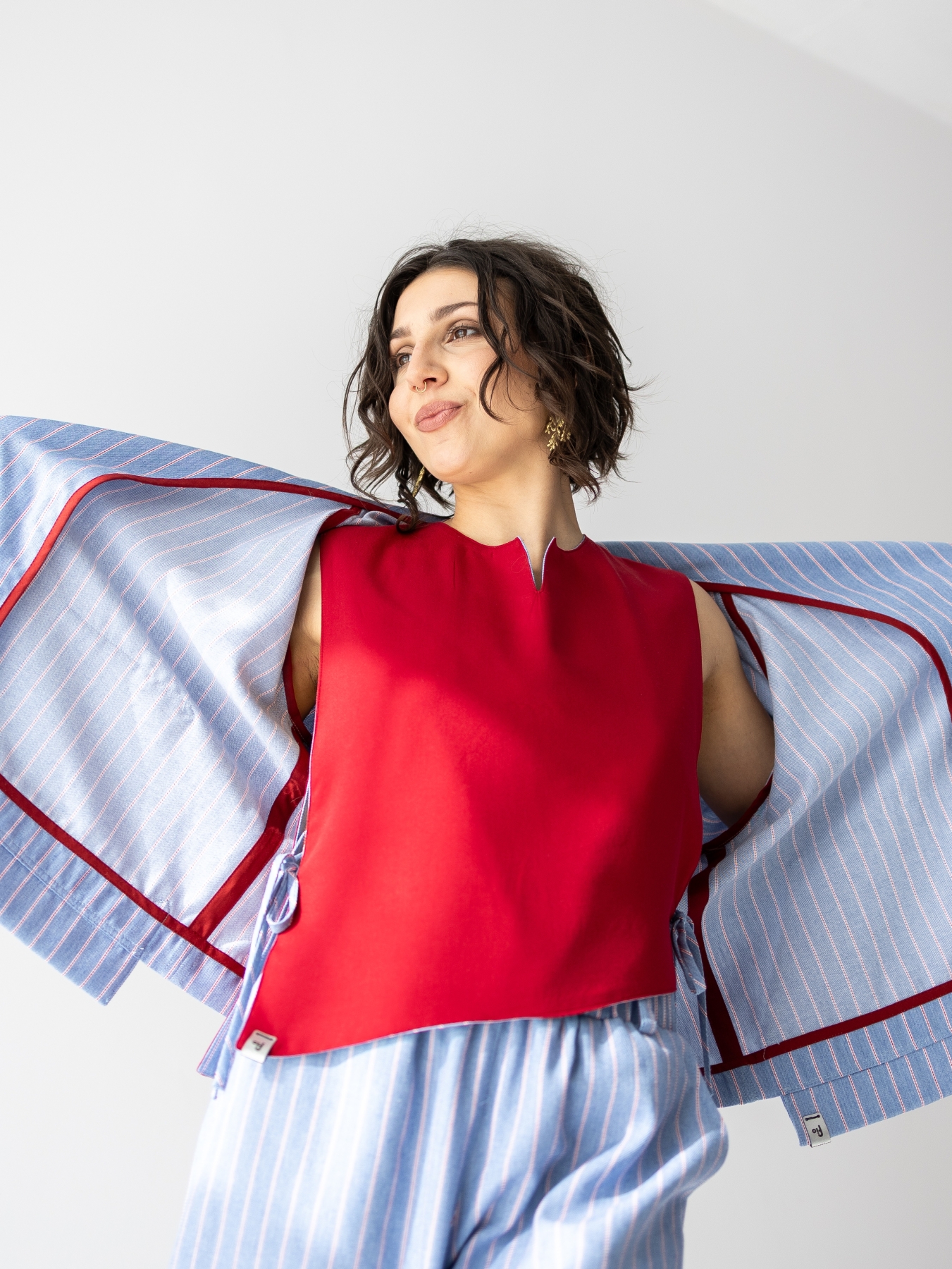 Jasnoniebieskie kimono Lucia w pionowy prążek, o luźnym fasonie i szerokim kołnierzu.