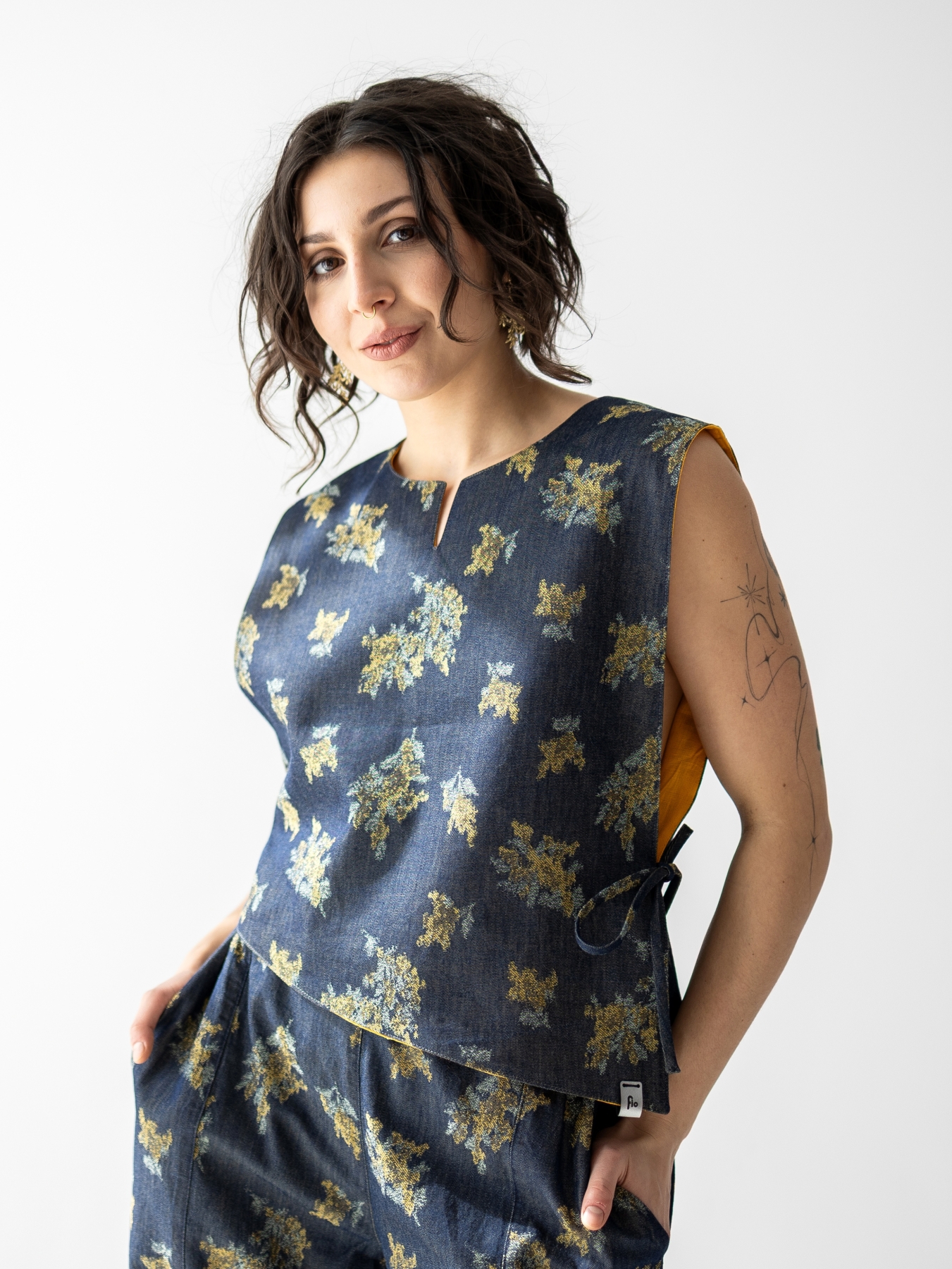 Modelka w dwustronnej kamizelce z lnu i cienkiego jeansu w kwiaty