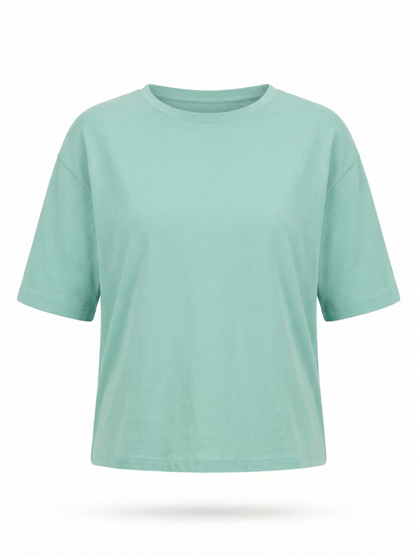 Modelka w miętowej BLUZCE MINT o swobodnym, lekko oversize’owym fasonie i krótkim rękawie.