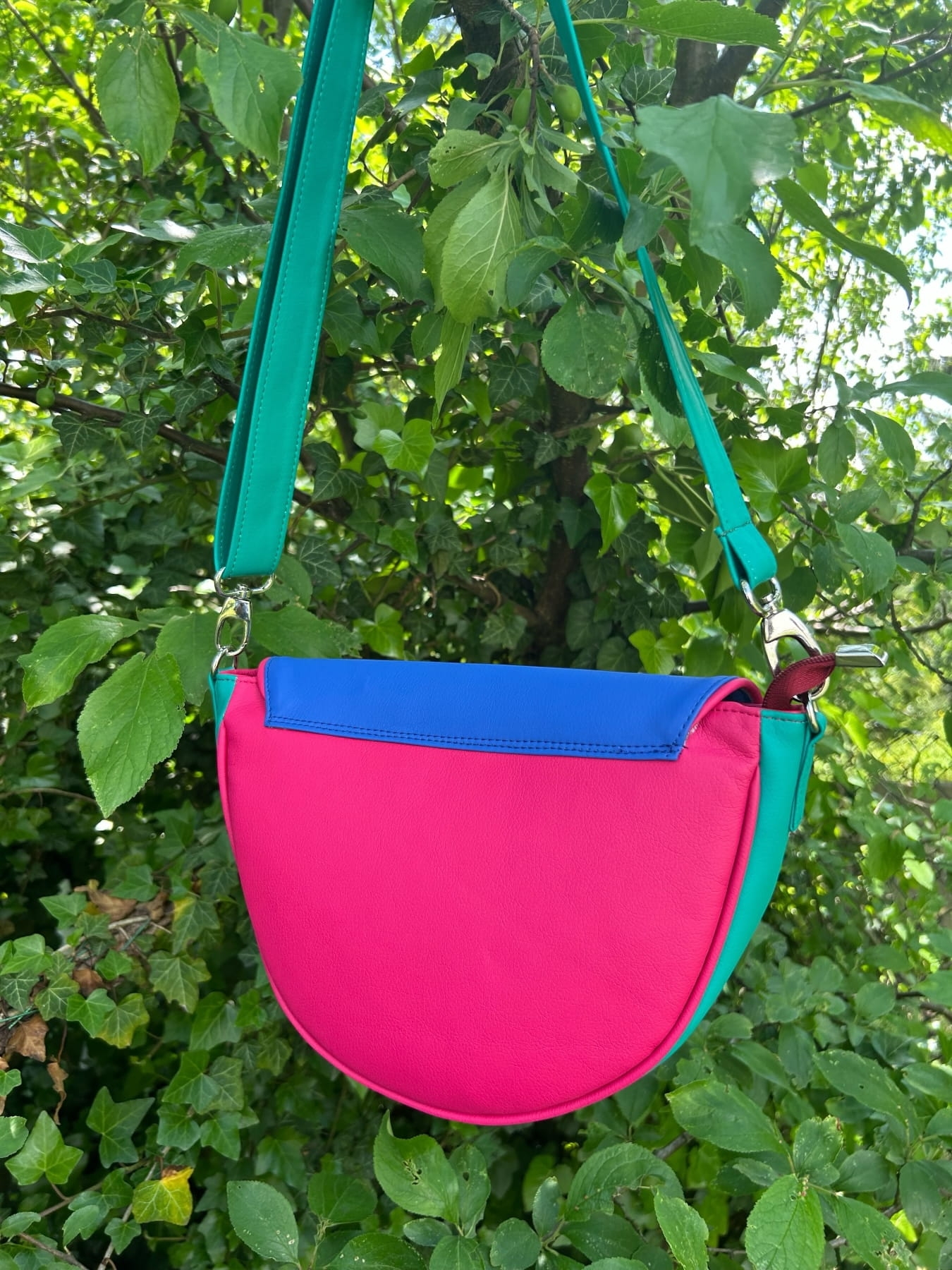 Nerka półokrągła zawieszona na pasku, widok od tyłu – różowy tył, niebieska góra i zielony bok.